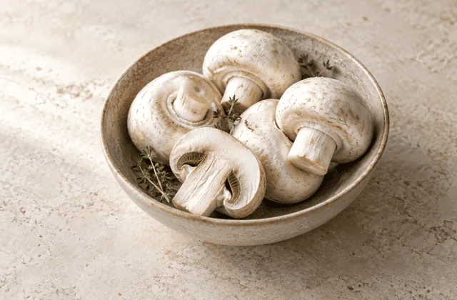Champignons de Paris frais dans un bol en grès