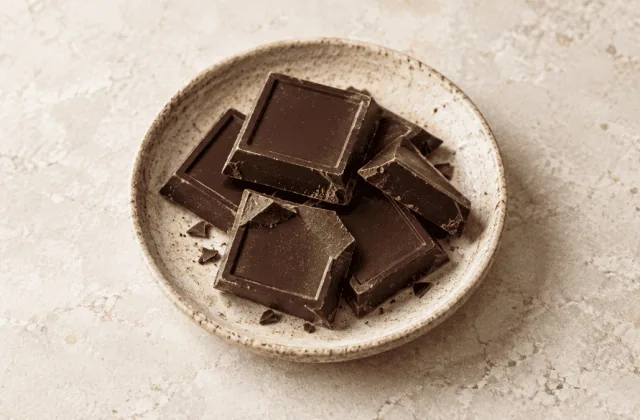 Carrés de chocolat noir sur une assiette en grès