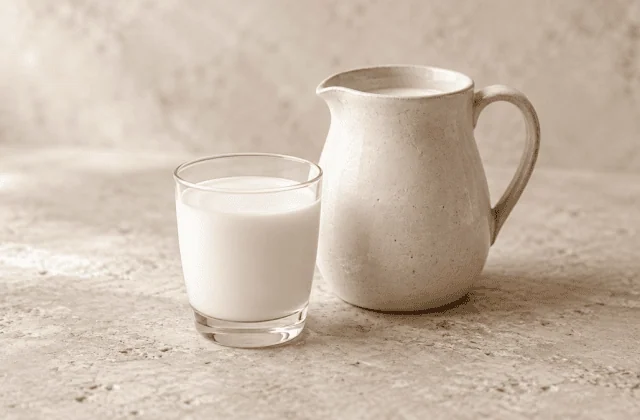 Lait frais dans un verre avec un pichet en céramique