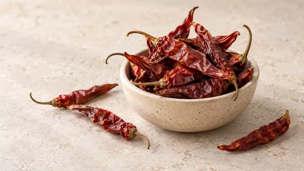 Piments rouges séchés entiers dans un bol artisanal