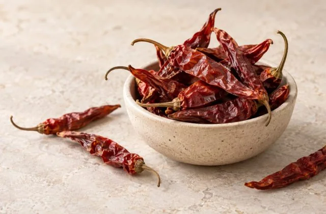 Piments rouges séchés entiers dans un bol artisanal