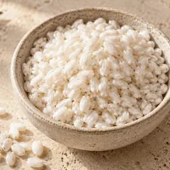 Riz Arborio cru aux grains courts et bombés dans un bol en grès