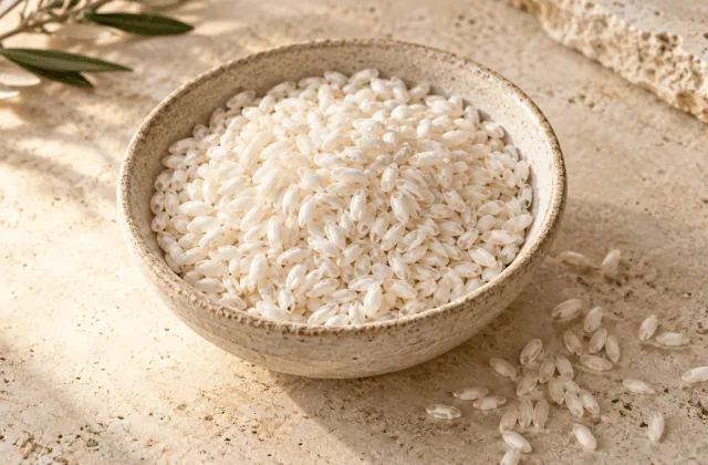 Riz Carnaroli cru aux grains légèrement allongés dans un bol en grès