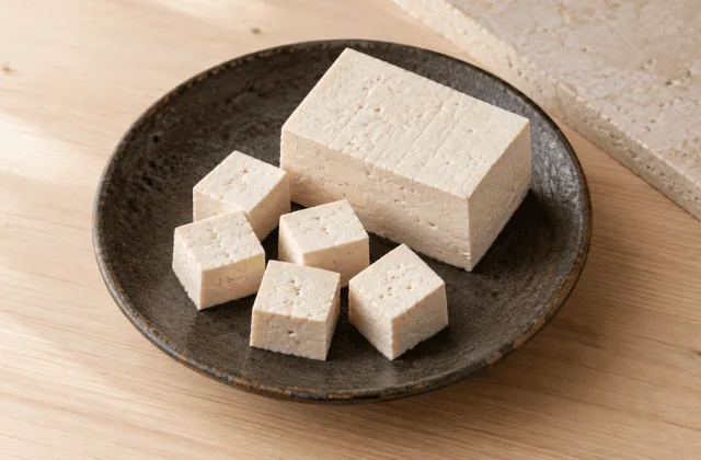 Tofu ferme nature en bloc et en cubes sur une assiette en céramique