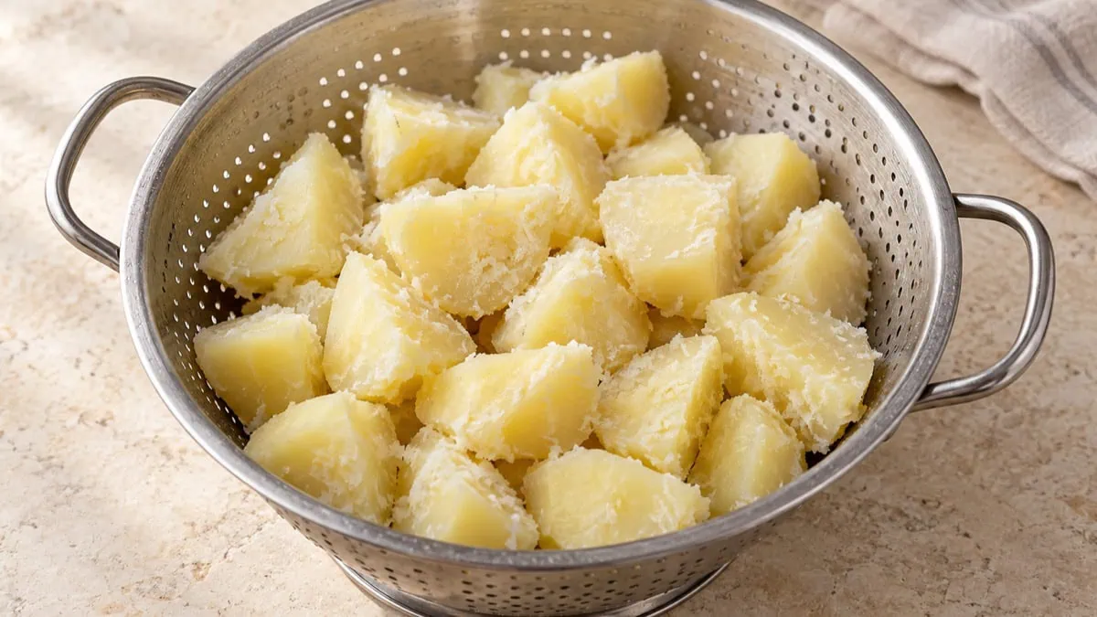 Pommes de terre précuites aux bords rugueux séchant dans une passoire