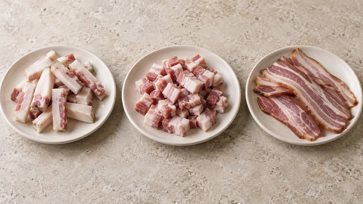 Guanciale en bâtonnets, pancetta en cubes et bacon en tranches présentés séparément