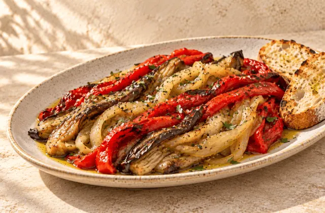 Escalivada catalane servie avec du pain grillé sur une assiette artisanale claire