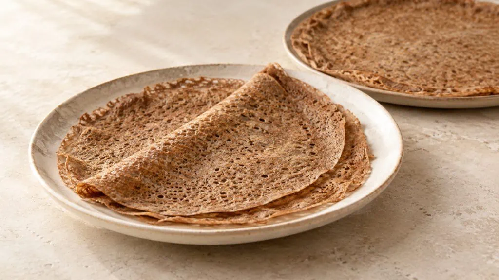 Galette de sarrasin nature fine et brun-gris sur une assiette claire