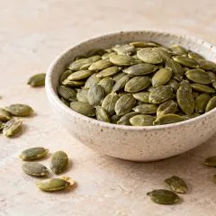 Graines de courge décortiquées vert olive dans une coupelle