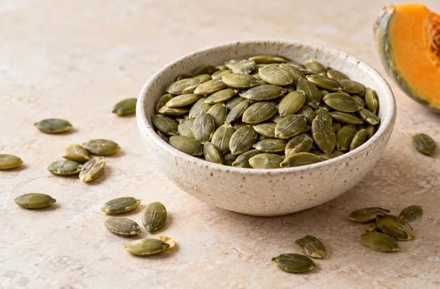 Graines de courge décortiquées vert olive dans une coupelle