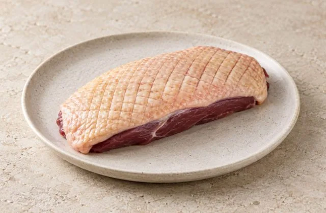Magret de canard tranché rosé avec peau croustillante, pommes de terre sarladaises et haricots verts
