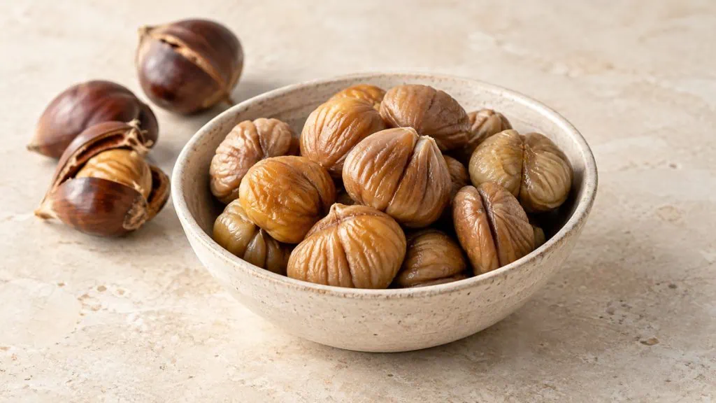 Marrons cuits et châtaignes entières dans un bol en grès