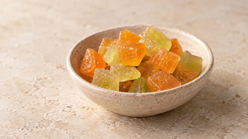 Morceaux de melon confit orange et vert pâle dans une coupelle