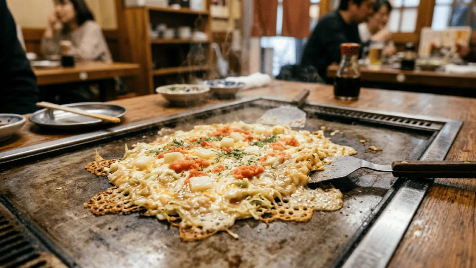 Monjayaki mentaiko, mochi et fromage en train de cuire sur la plaque teppan d’un restaurant de Tokyo
